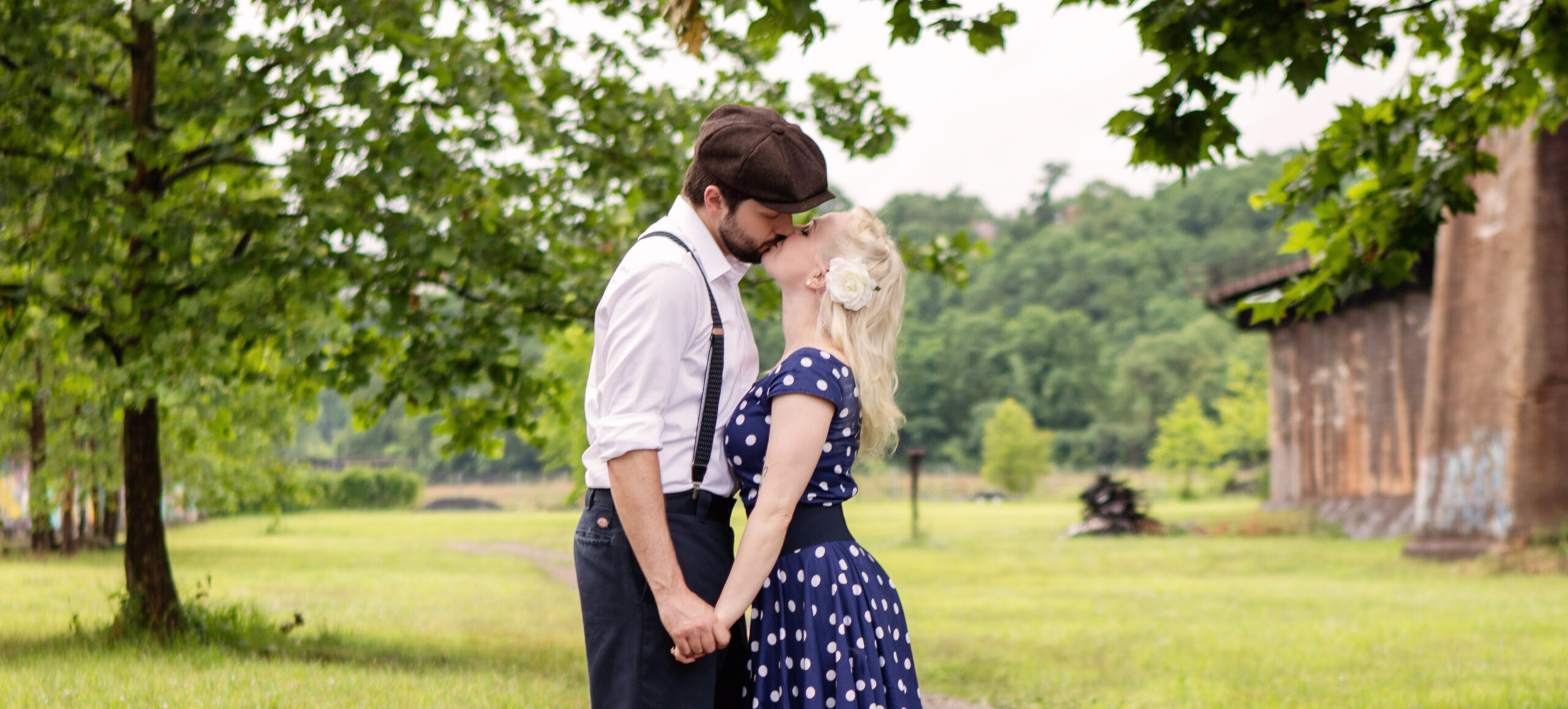 a man and woman are kissing in the grass