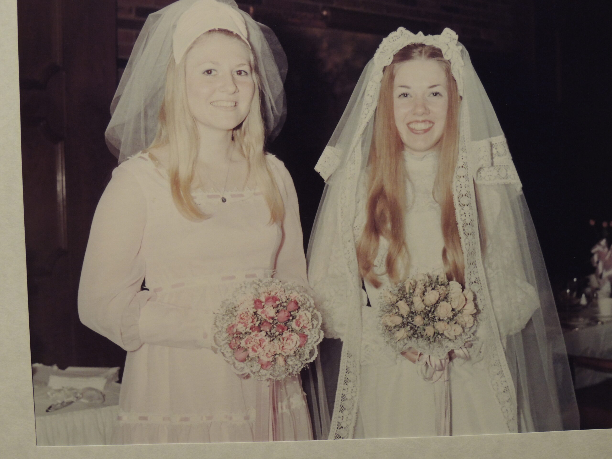 two girls dressed in wedding attire standing next to each other