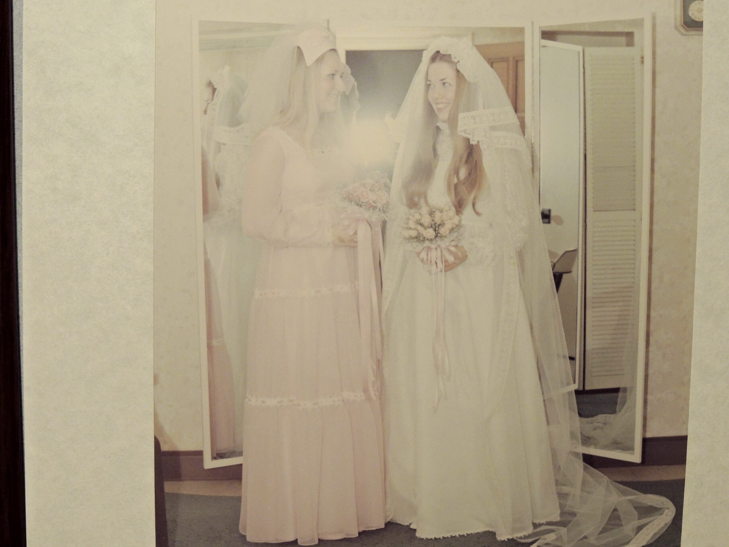 two women in wedding dresses standing next to each other