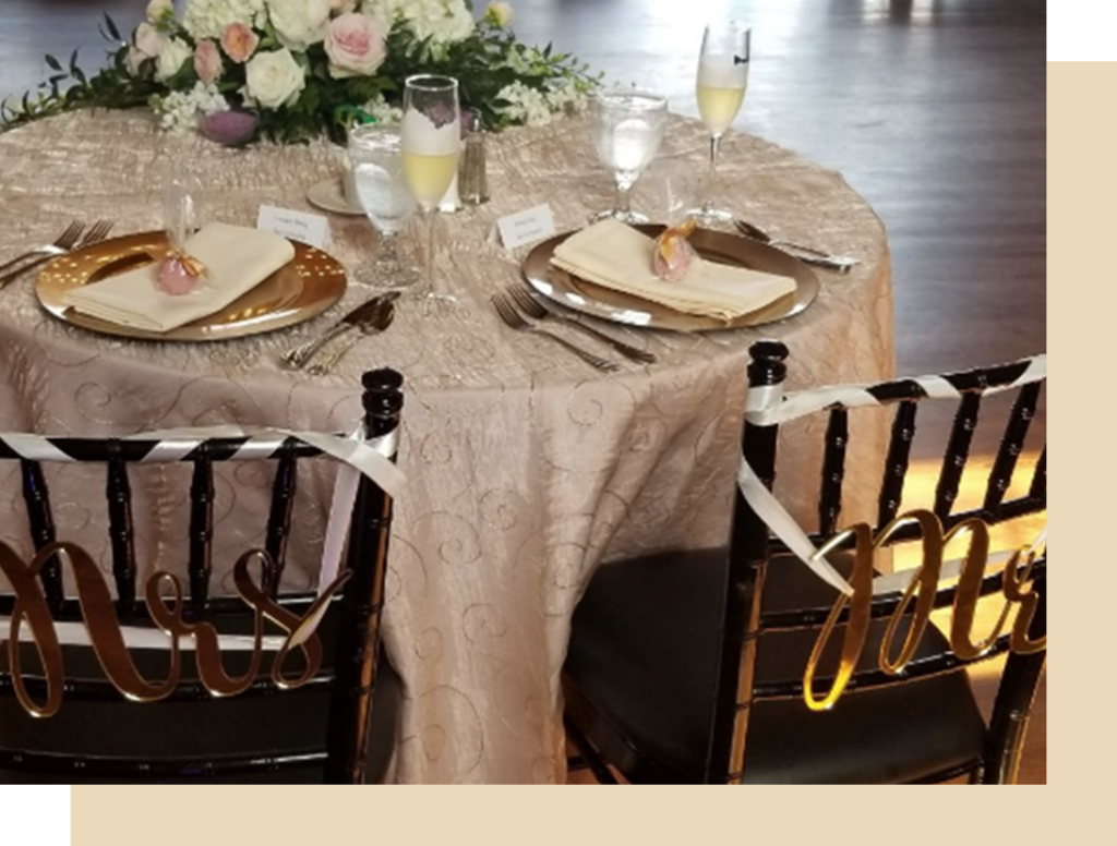 a table set for two with gold plates and silverware