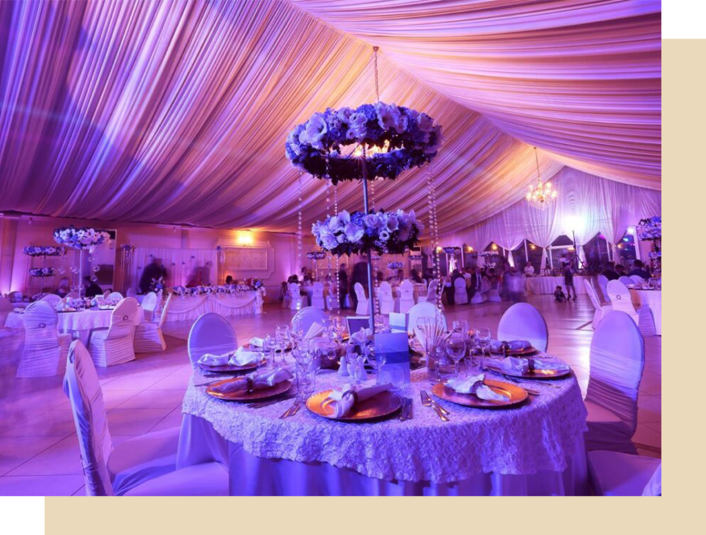 a banquet hall with purple lighting and white linens